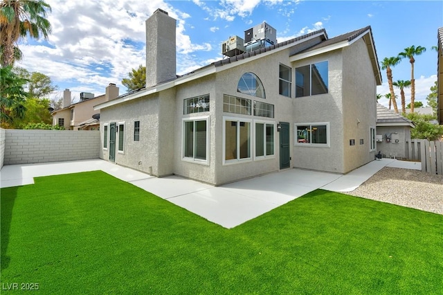 rear view of house with a yard, central AC unit, and a patio area