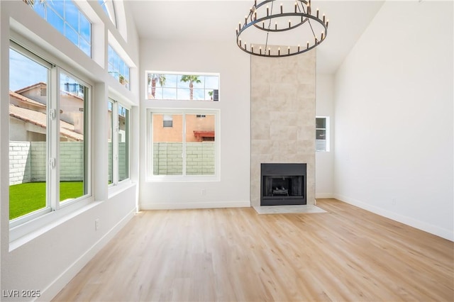 unfurnished sunroom featuring a large fireplace, a notable chandelier, and plenty of natural light