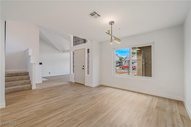 interior space with light hardwood / wood-style floors and an inviting chandelier