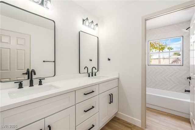 bathroom featuring shower / washtub combination, wood-type flooring, and vanity