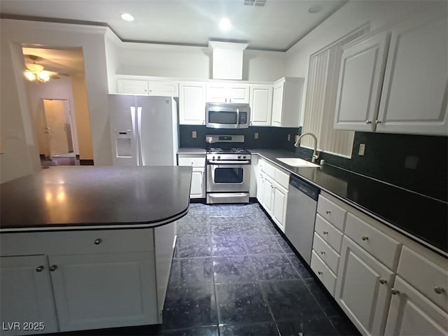 kitchen featuring appliances with stainless steel finishes, white cabinets, backsplash, and sink