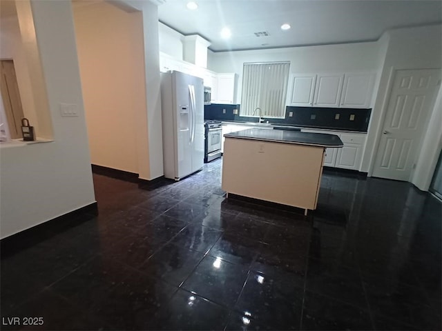 kitchen with stainless steel appliances, decorative backsplash, a kitchen island, white cabinets, and sink