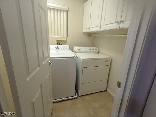 washroom with cabinets, separate washer and dryer, and light tile patterned floors