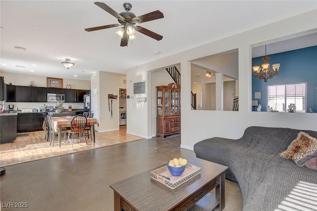 living room with ceiling fan with notable chandelier