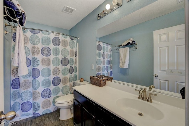 bathroom with toilet, wood-type flooring, and vanity