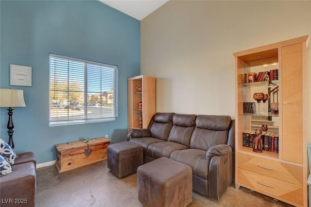 living room with a high ceiling and concrete floors