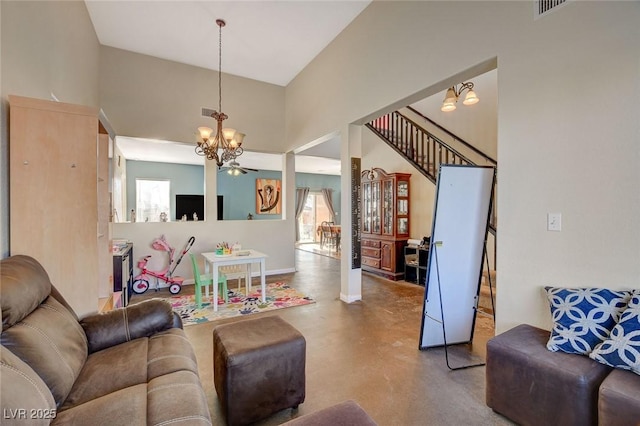 living room with a high ceiling, concrete floors, and a notable chandelier