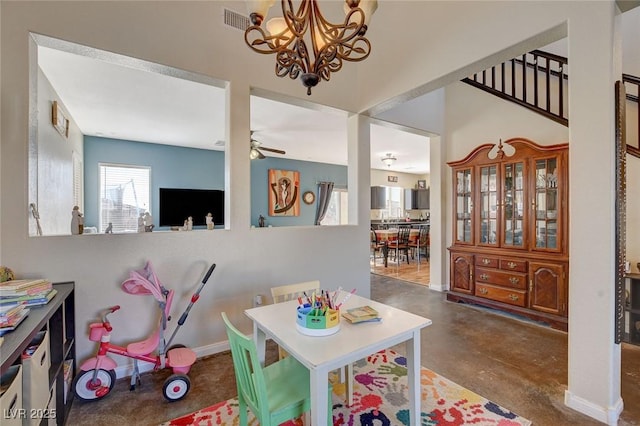 playroom featuring ceiling fan with notable chandelier