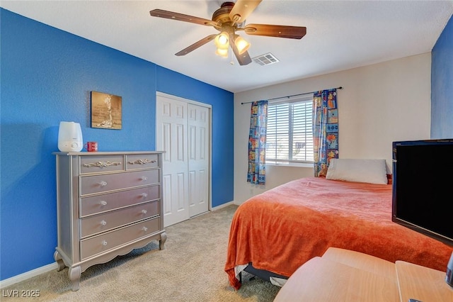 carpeted bedroom featuring ceiling fan and a closet