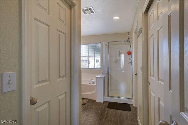 bathroom with wood-type flooring and plus walk in shower