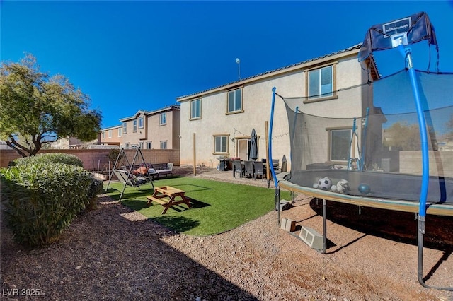 back of property with a patio and a trampoline