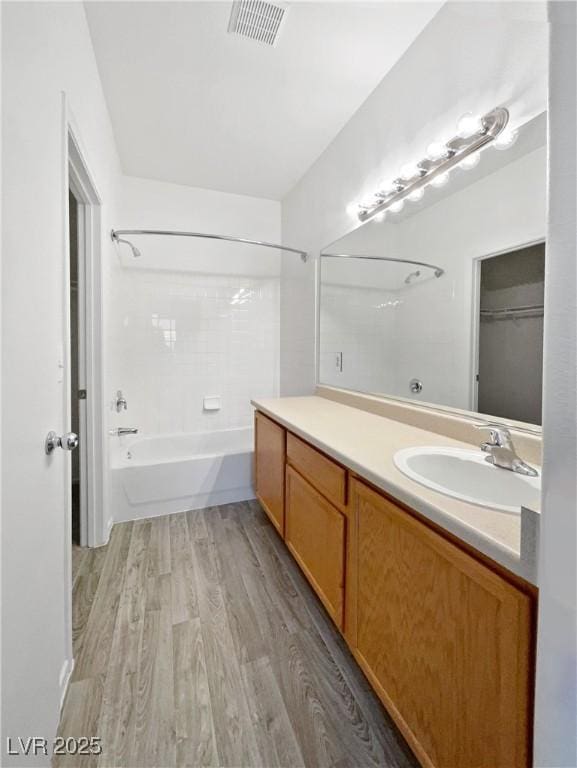 bathroom featuring shower / tub combination, hardwood / wood-style flooring, and vanity