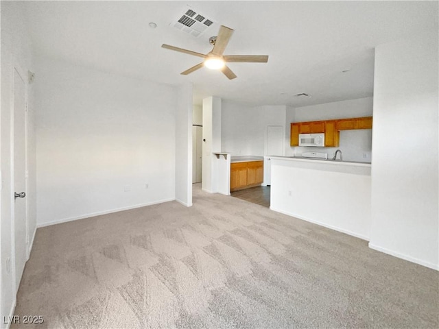 unfurnished living room with carpet floors and ceiling fan