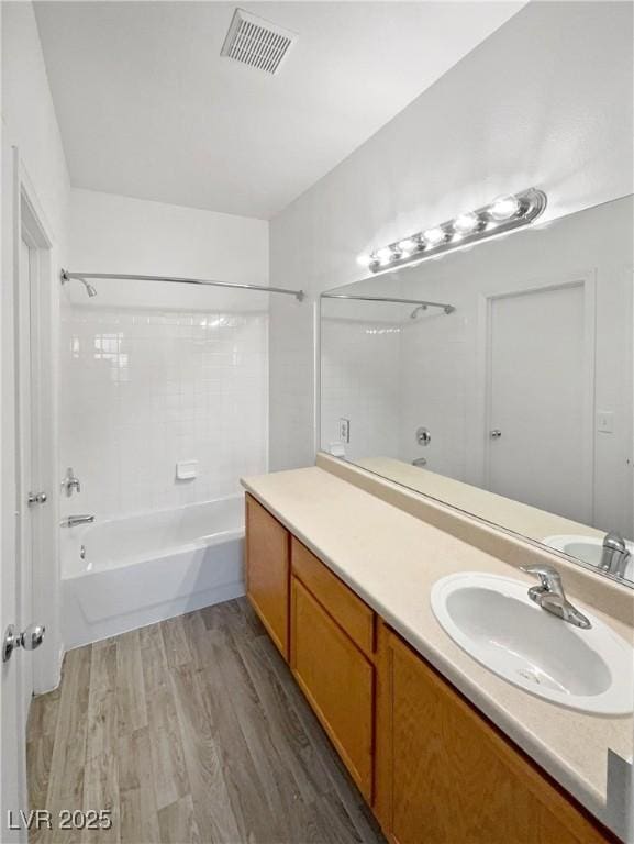 bathroom featuring vanity, wood-type flooring, and  shower combination