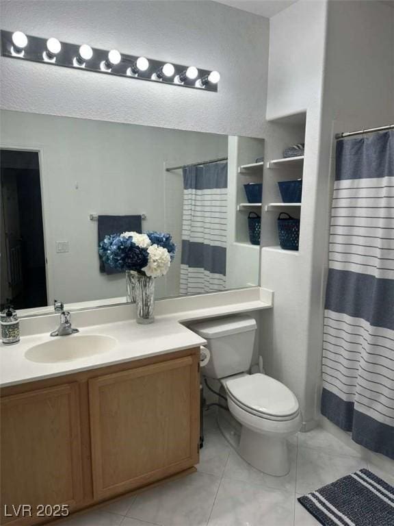 bathroom with toilet, vanity, tile patterned flooring, and walk in shower