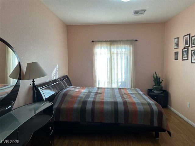 bedroom with dark hardwood / wood-style floors