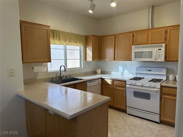 kitchen featuring sink, white appliances, and kitchen peninsula