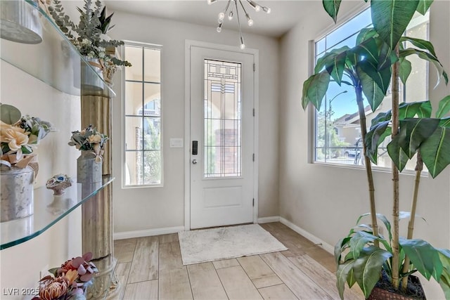 entryway with a chandelier and plenty of natural light