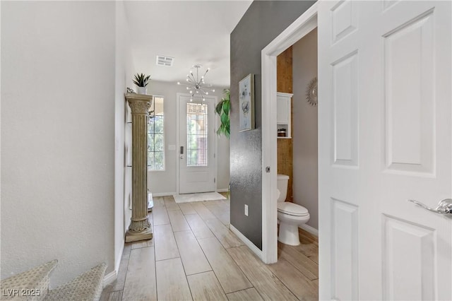 bathroom featuring toilet and an inviting chandelier