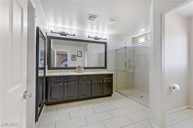 bathroom featuring tile patterned flooring, vanity, and a shower with shower door