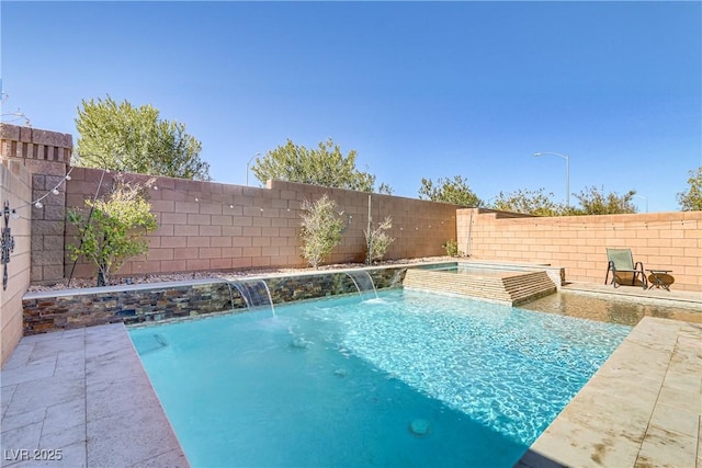 view of swimming pool featuring pool water feature and an in ground hot tub