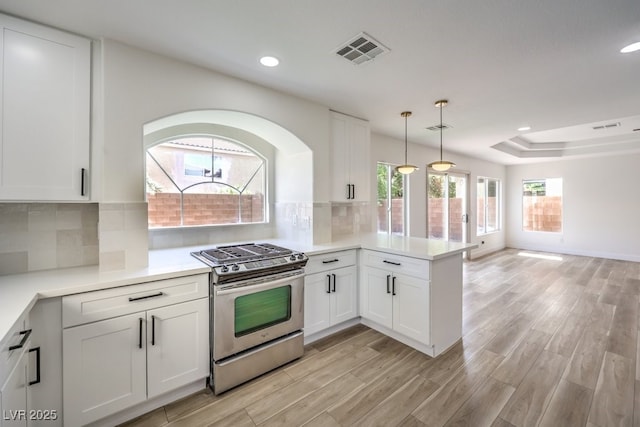 kitchen with white cabinetry, kitchen peninsula, gas range, and decorative backsplash