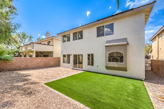 back of property with a patio area and a yard