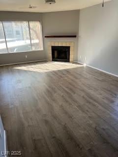 unfurnished living room with a tiled fireplace and hardwood / wood-style floors