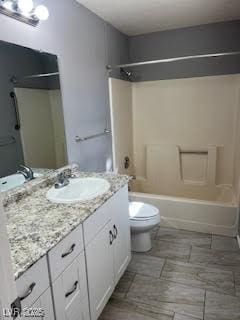 full bathroom featuring washtub / shower combination, vanity, and toilet