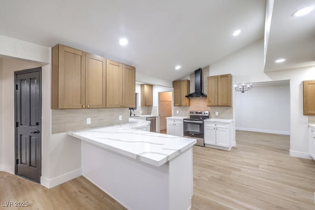 kitchen with electric range, vaulted ceiling, light hardwood / wood-style floors, kitchen peninsula, and wall chimney exhaust hood