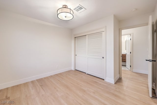 unfurnished bedroom featuring a closet and light wood-type flooring