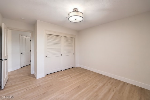 unfurnished bedroom featuring a closet and light hardwood / wood-style flooring