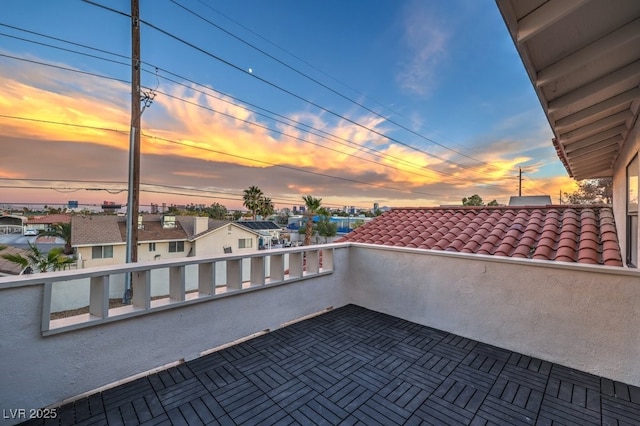 patio terrace at dusk featuring a balcony