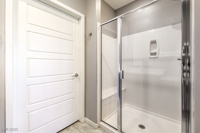 bathroom featuring an enclosed shower and tile patterned flooring