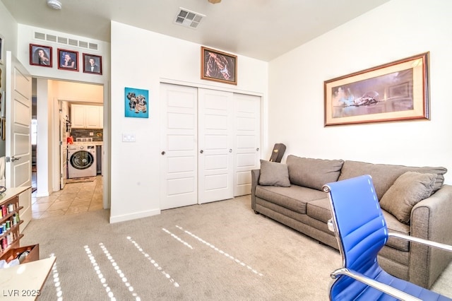 carpeted living room featuring washer / dryer