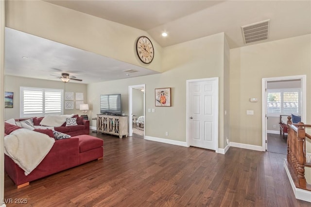 living room featuring ceiling fan, lofted ceiling, a wealth of natural light, and dark hardwood / wood-style floors