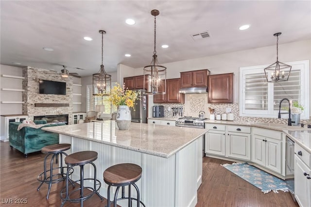 kitchen with sink, a kitchen island, white cabinetry, and a breakfast bar area