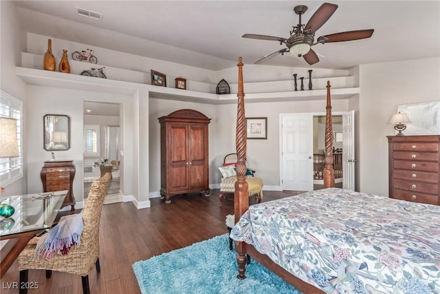 bedroom with dark hardwood / wood-style flooring and ceiling fan