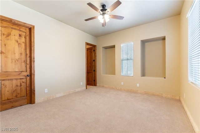 carpeted spare room with ceiling fan