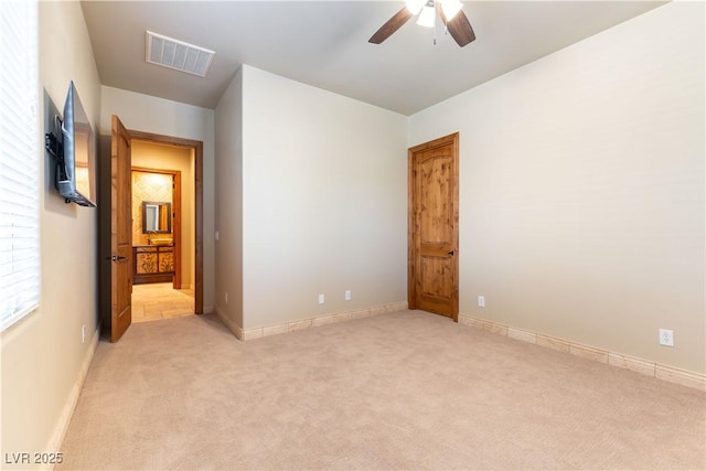 spare room with ceiling fan and light carpet