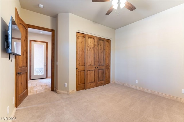 unfurnished bedroom with a closet, ceiling fan, and light carpet