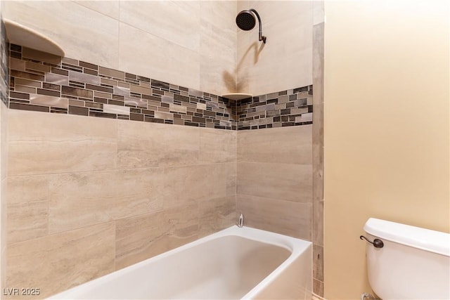 bathroom featuring toilet and tiled shower / bath