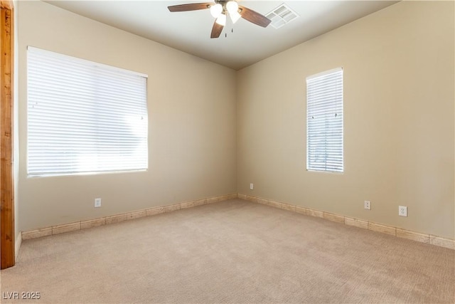 carpeted spare room featuring ceiling fan