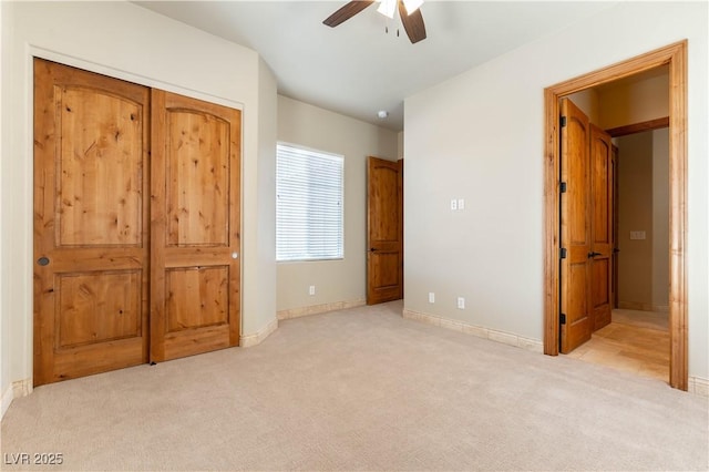 unfurnished bedroom with a closet, ceiling fan, and light carpet