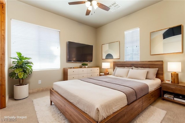 carpeted bedroom with ceiling fan and multiple windows