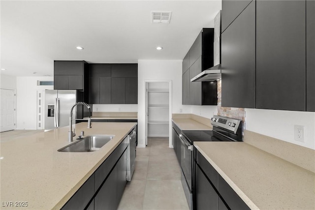 kitchen with stainless steel appliances, wall chimney exhaust hood, and sink