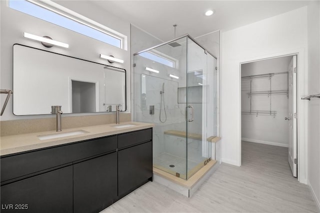 bathroom featuring a shower with door, vanity, and wood-type flooring