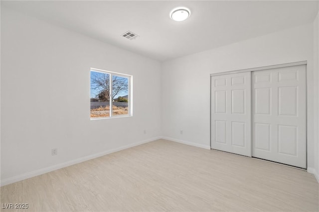 unfurnished bedroom featuring a closet and light hardwood / wood-style floors