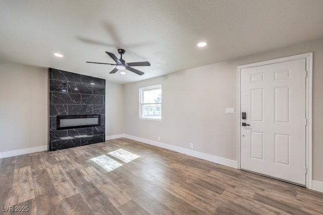 unfurnished living room featuring a fireplace, ceiling fan, and hardwood / wood-style floors