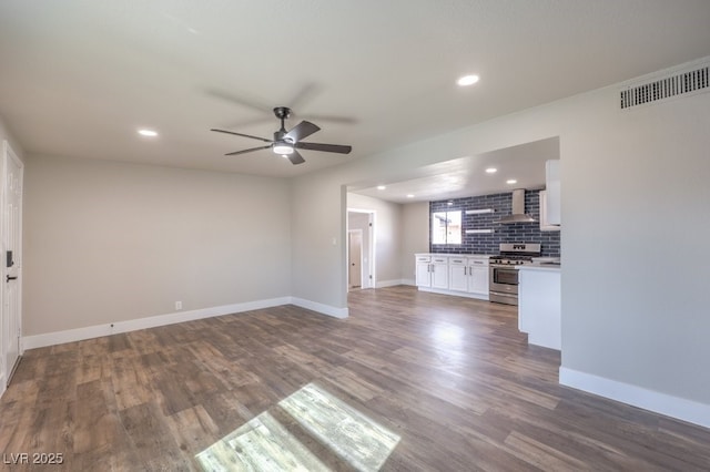 unfurnished living room with dark wood-type flooring and ceiling fan